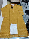 Yellow embroidered kurta with white pants on a glass surface